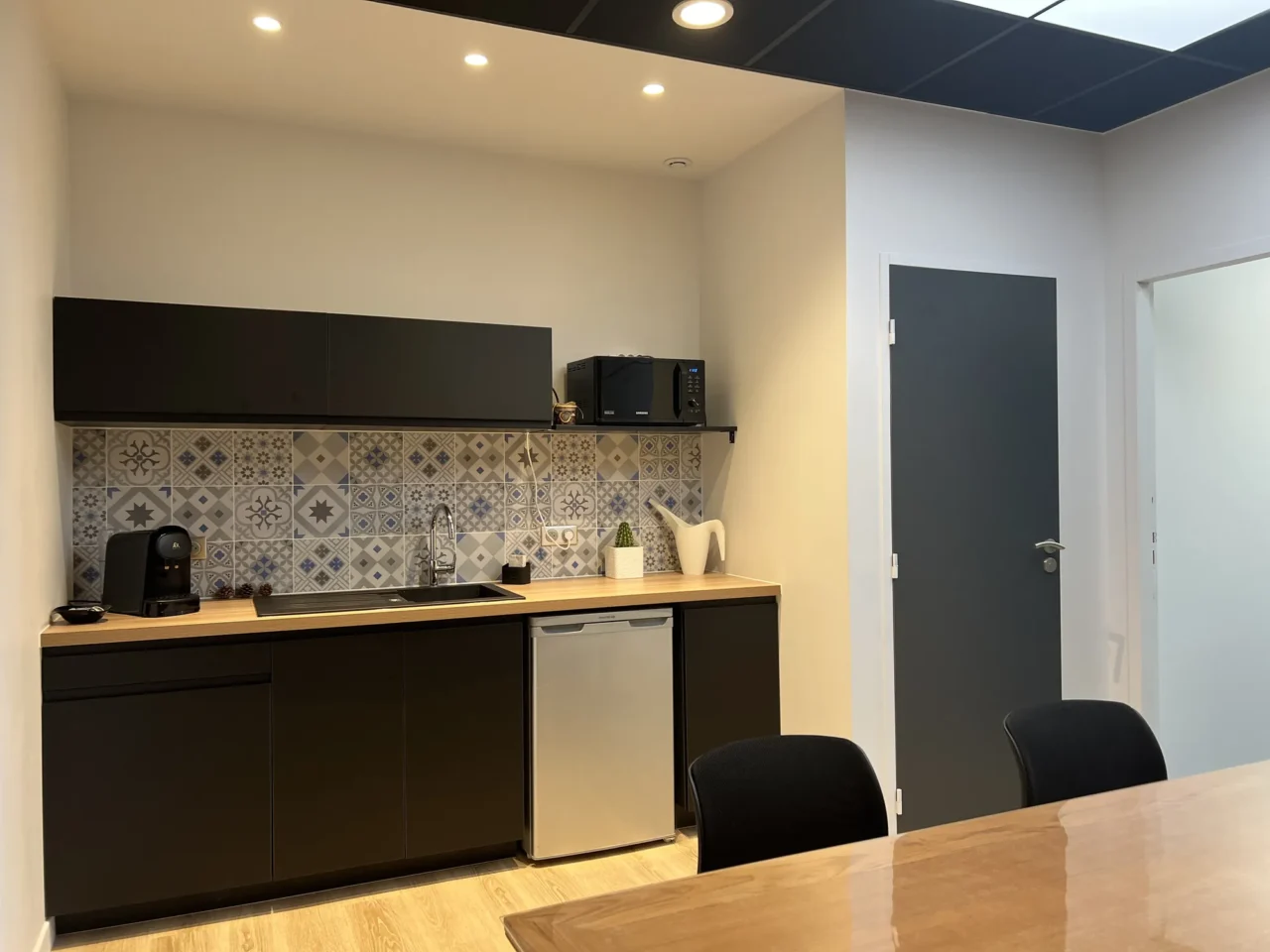 Cuisine aménagée sur mesure par ECRT, alliant fonctionnalité et design pour un espace de travail optimisé.