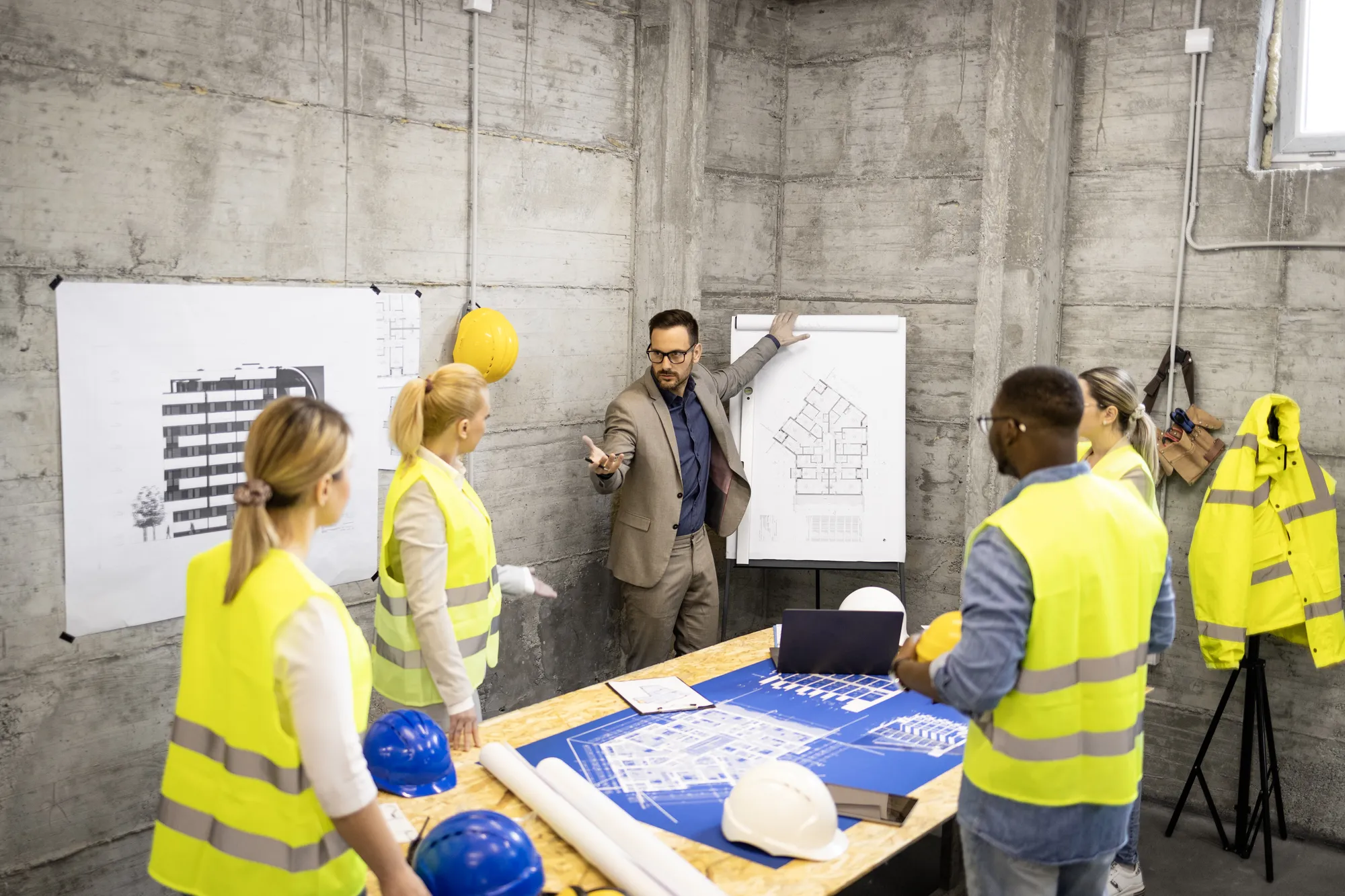 Équipe ECRT en réunion de planification de travaux, rôle de maître d'œuvre pour projets de construction professionnels
